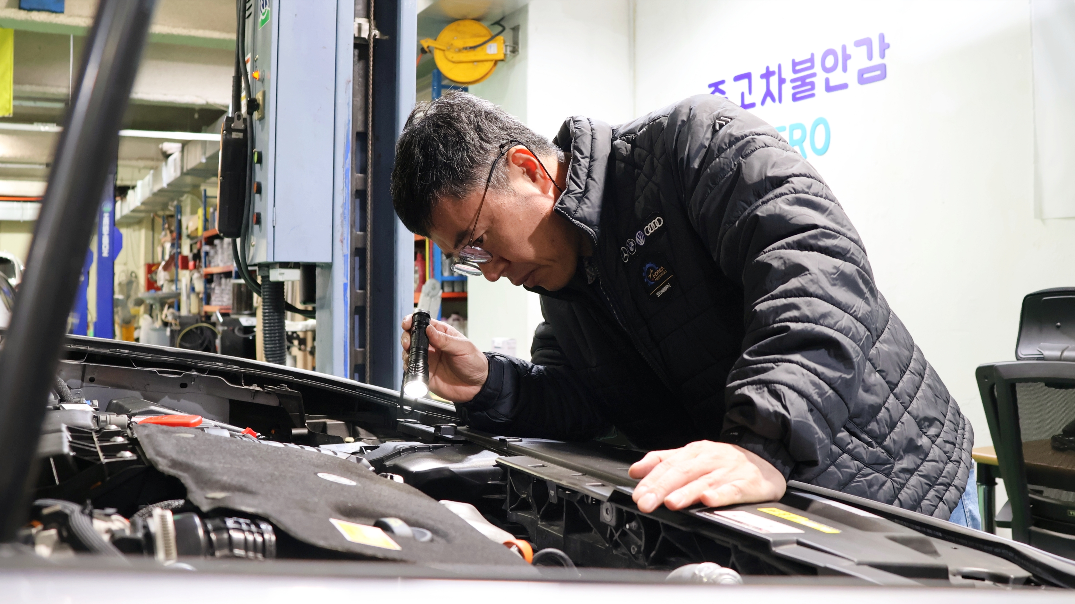 차산후 정비사가 리프트 위 차량을 점검하는 모습